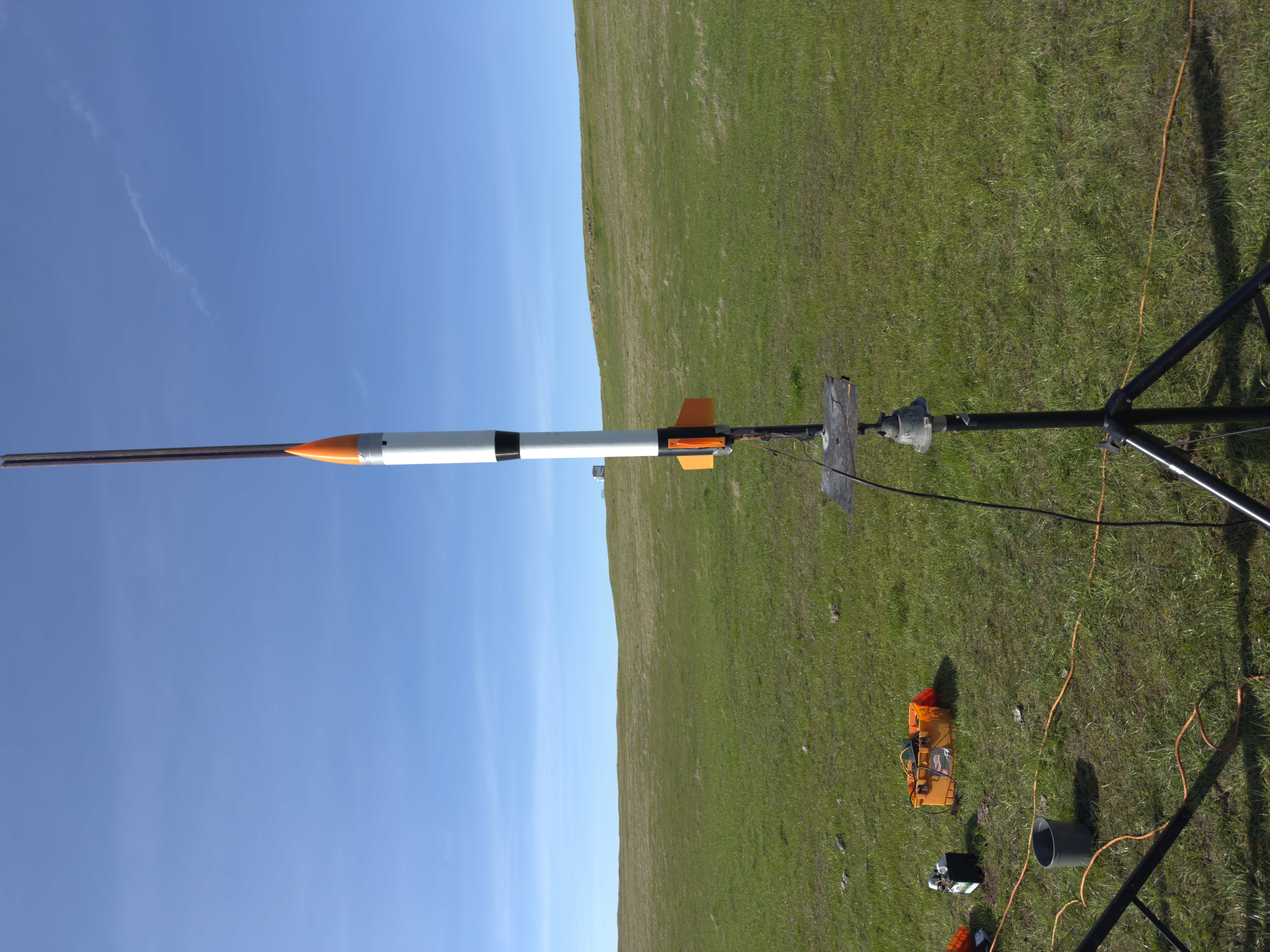 Model rocket mounted on launch pad in open field